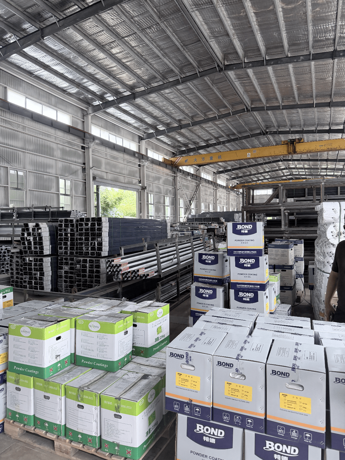 Aluminium profiles, steel sections and coated stock staged inside the manufacturing facility