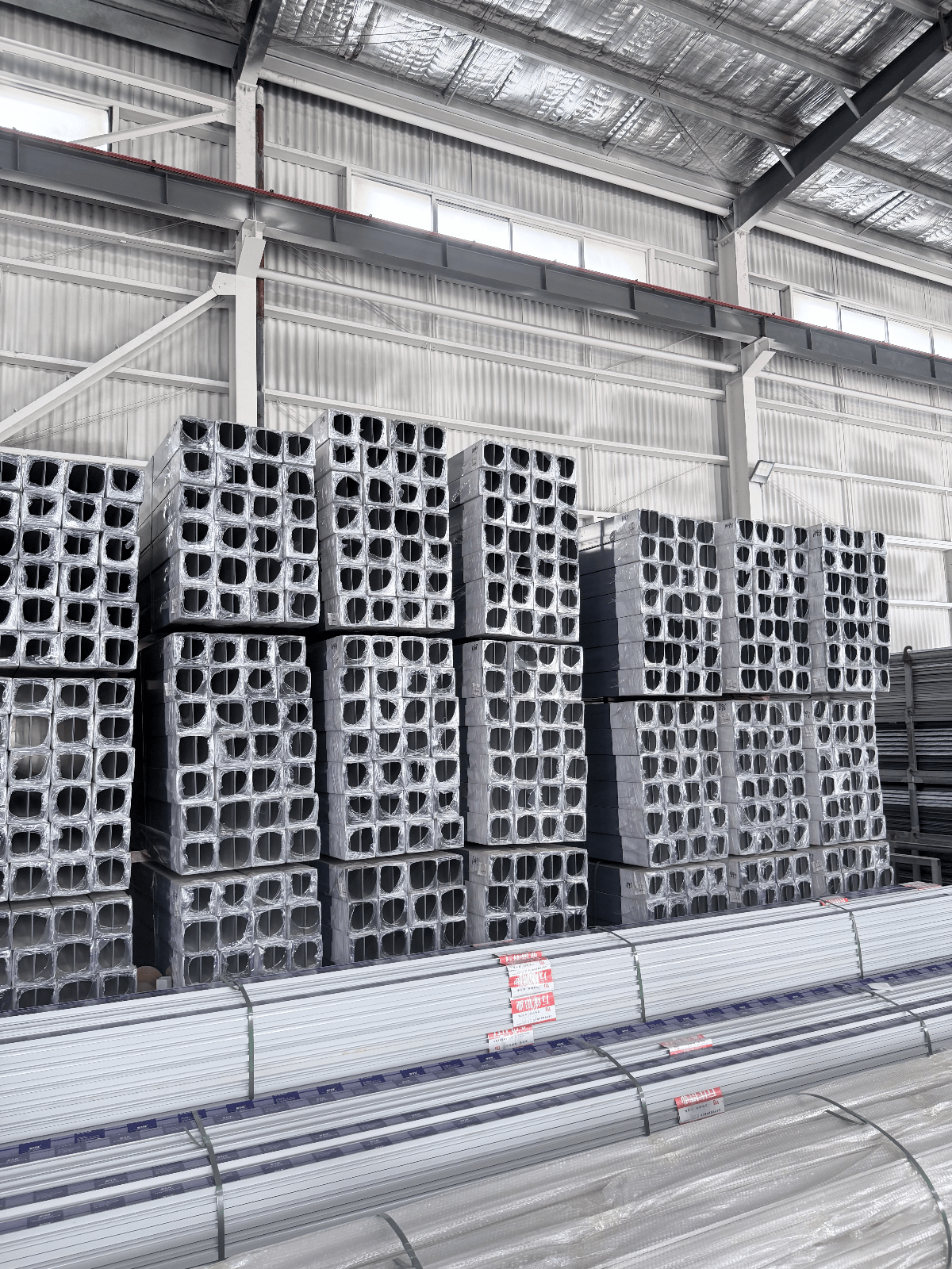 Bundled aluminium profile stock stacked and wrapped, ready for coating and dispatch